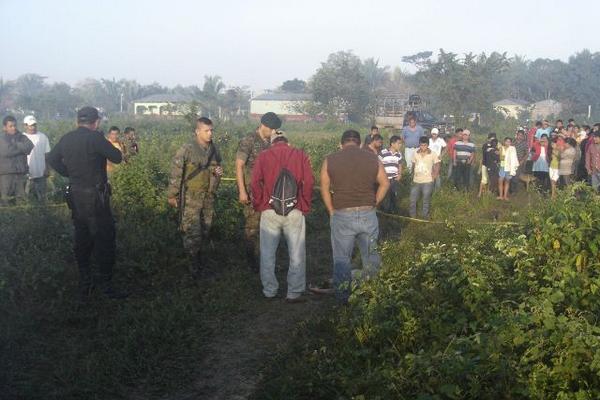 Curiosos observan el cadáver de Pablo Benedicto Noguera, quien murió de forma violenta en Sayaxché. (Foto Prensa Libre: Rigoberto Escobar)