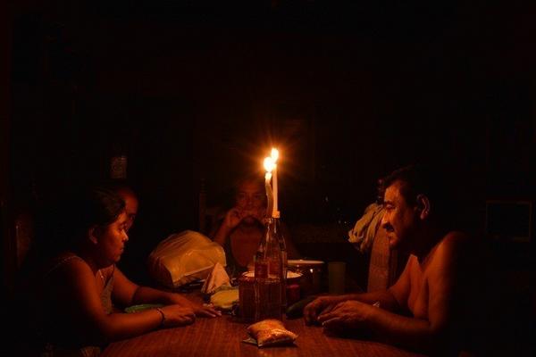 Familia que reside en el barrio Cruz de Mayo, en Zacapa, se alumbra con candelas debido al corte de energía generado por las lluvias. (Foto Prensa Libre: Víctor Gómez)   <br _mce_bogus="1"/>