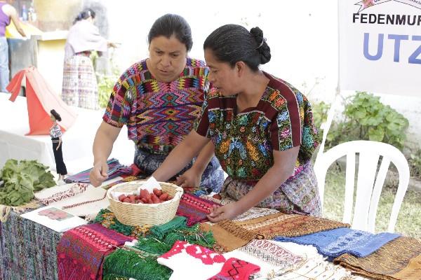 Féminas indígenas preparan muestras de producto elaborados por ellas, durante la visita de autoridades gubernamentales.