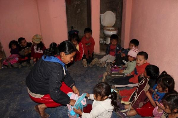 Debido a la falta de mobiliario, niños de preprimaria de Chajul estudian en el suelo.