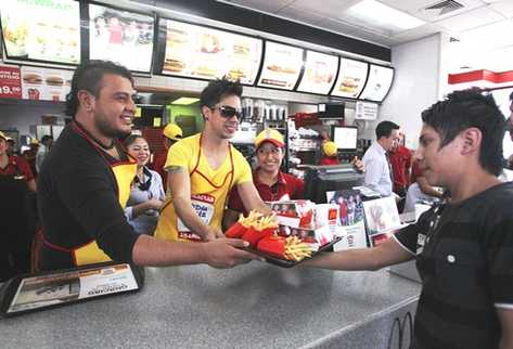 Édgar Bran y JP de la agrupación Gángster participaron en el McDía Feliz y vendieron varios Big Mac en varias tiendas. (Foto Prensa Libre: Keneth Cruz)