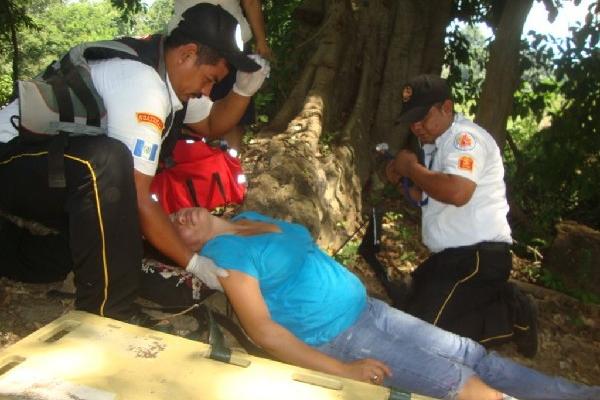 En el simulacro de inundación, bomberos atienden a mujer.