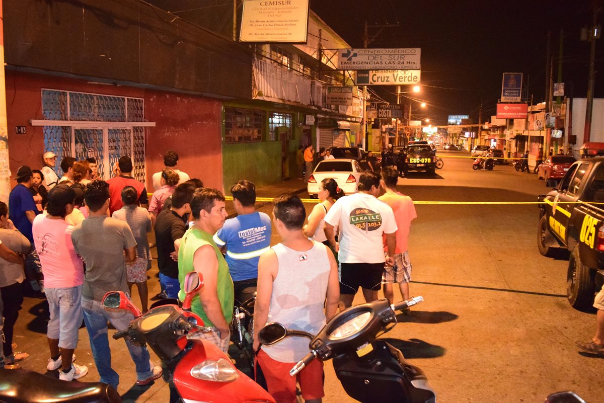 Agentes de la PNC acordonan el vehículo en el que una mujer fue atacada a balazos, en la cabecera de Escuintla. (Foto Prensa Libre: Carlos E. Paredes)