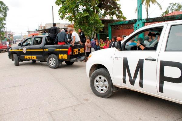 Agentes policiales y fiscales del Ministerio Público ordenan el traslado del cuerpo a la morgue de Inacif, en San Benito, Petén. (Foto Prensa Libre: Rigoberto Escobar).