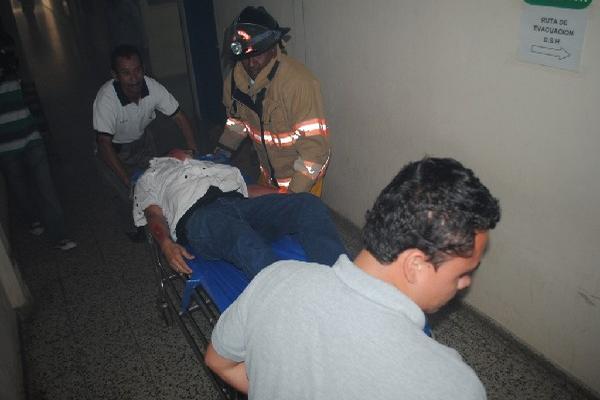 Bombero y personal de hospital auxilian a herido.