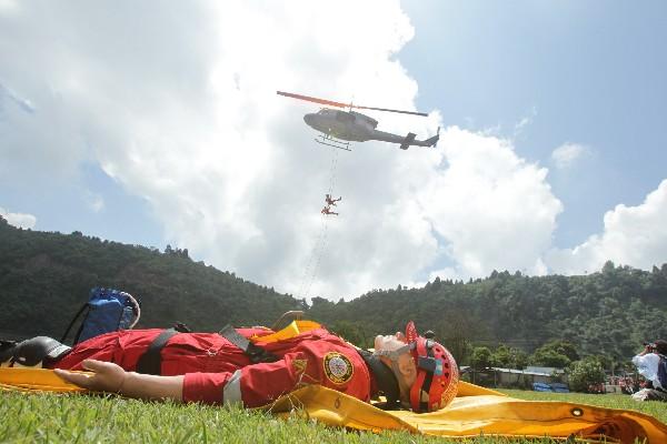 Socorristas descienden de un helicóptero para simular un rescate aéreo en una zona aislada.