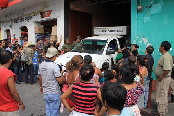 Curiosos observan al personal del MP que efectúa el cateo en el establecimiento. (Foto Prensa Libre: Carlos Paredes)<br _mce_bogus="1"/>