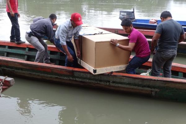 Caja en que fue repatriado féretro con el cádaver es llevado a la comunidad Tierra Blanca, de Sayaxché. (Foto Prensa Libre: Rigoberto Escobar)