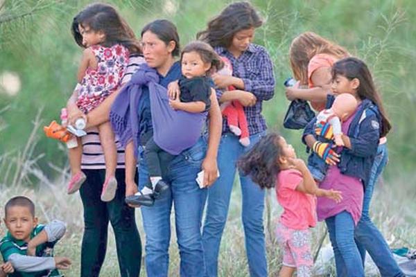 Un grupo  de migrantes centroamericanos espera a la Patrulla Fronteriza estadounidense para ser trasladados a un albergue. (Foto Prensa Libre: ARCHIVO)