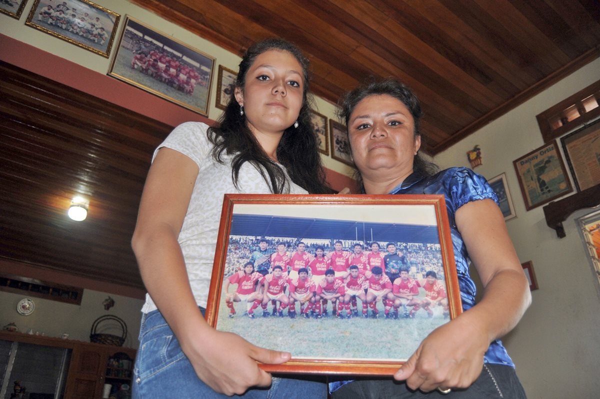 Esly de 14 años junto a su mamá, Esly viuda de Ortíz, muestran un cuadro de Dany Ortíz en su etapa con Municipal. (Foto Prensa Libre: Alexander Coyoy)