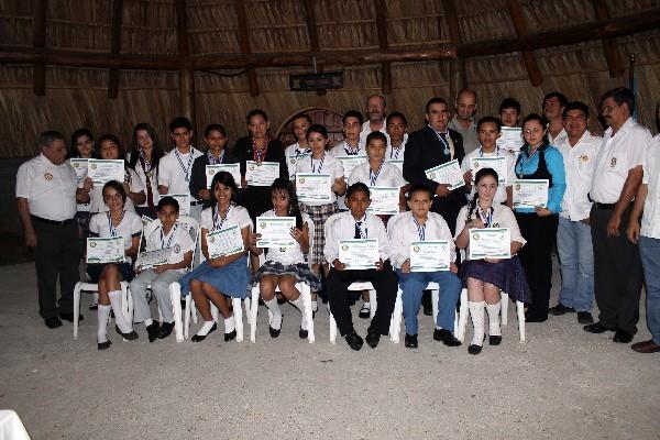 Galardonados muestran diplomas.