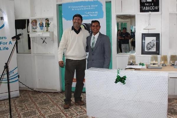 Melvin SAndoval—derecha— recibe premio de manos de  Réne Martínez, de Bayer Guatemala.