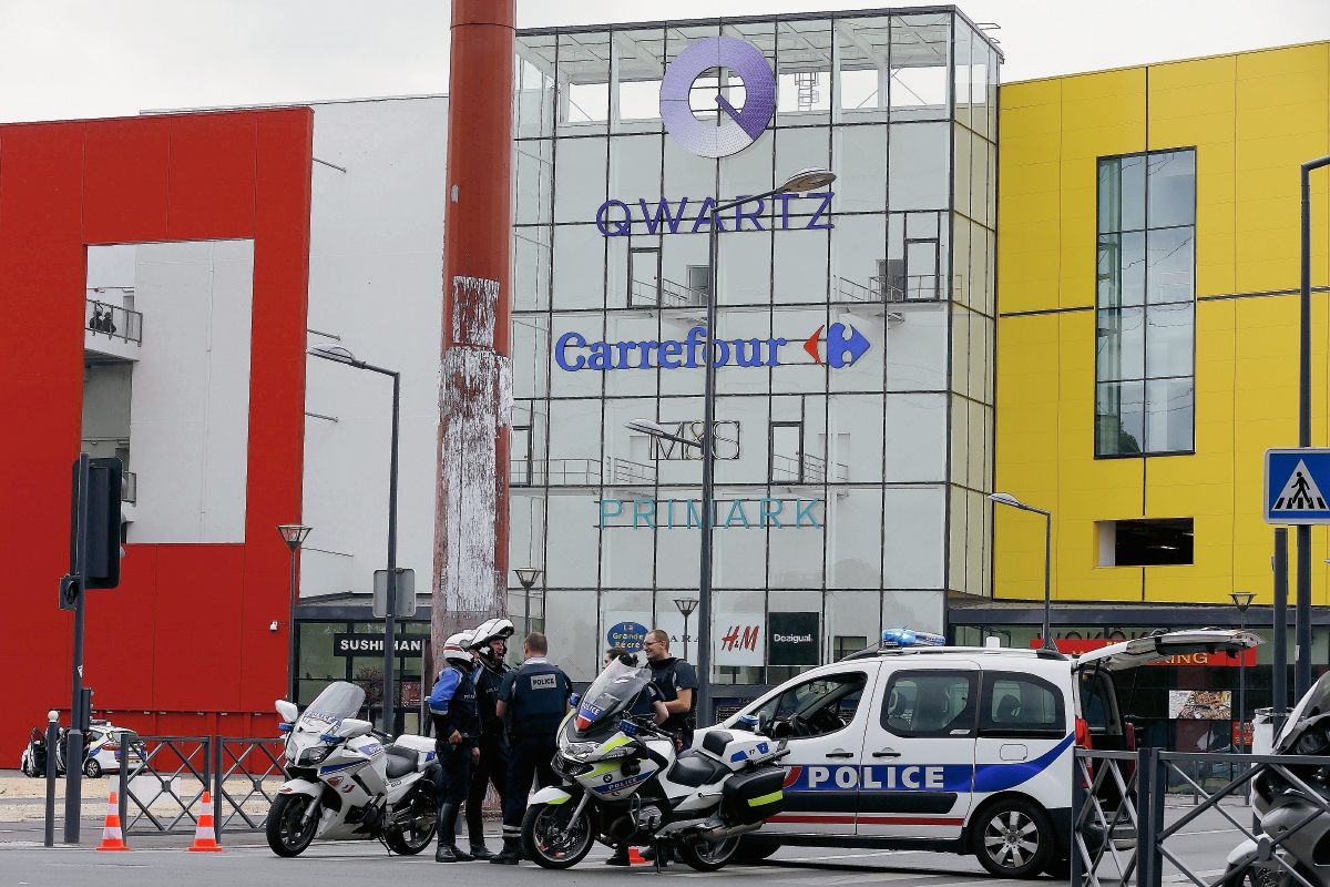 La Policía francesa espera afuera del centro comercial Qwartz in Villeneuve-La-Garenne, Francia después de que 18 rehenes fueron liberados. (Foto Prensa Libre: AFP).