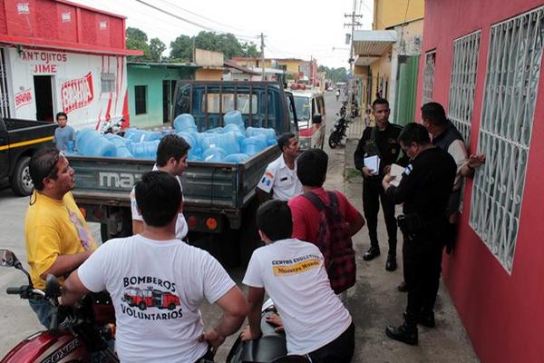 Bomberos dan detalles a la PNC sobre el asalto que sufrieron. (Foto Prensa Libre: Rolando Miranda)<br _mce_bogus="1"/>