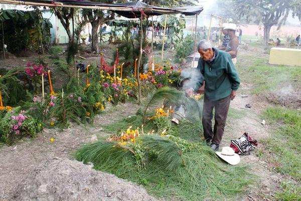 Máximo Xoco Yol hace un ritual al pie de la tumba de sus seres queridos. (Foto Prensa Libre: Carlos Grave)<br _mce_bogus="1"/>