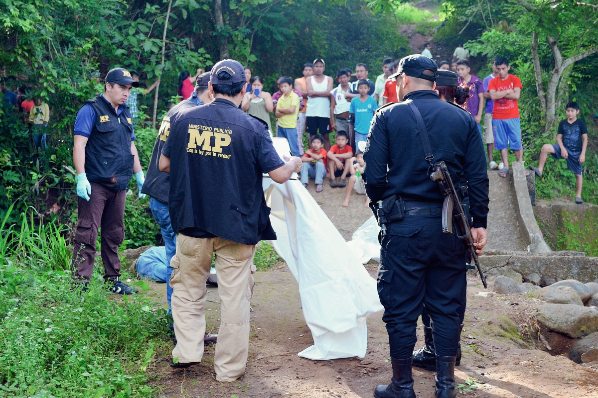 Peritos del  Ministerio Público recogen evidencias en la escena del crimen en El Asintal, Retalhuleu. (Foto Prensa Libre: Jorge Tizol)