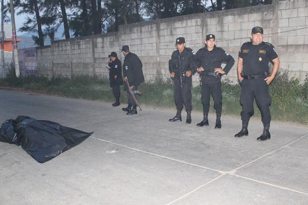 Agentes de la Policía Nacional Civil observan la bolsa que contiene los restos del salvadoreño asesinado. (Foto Prensa Libre: Óscar González)<br _mce_bogus="1"/>