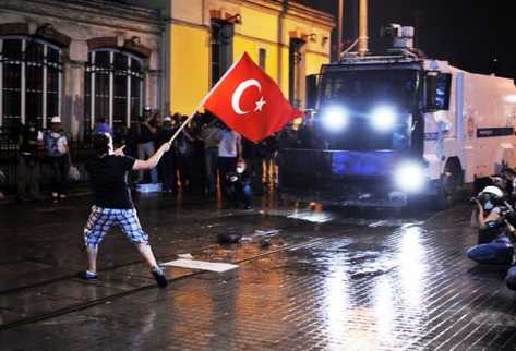 Un protestante turco ondea la bandera de ese país en la plaza Taksim frente a un tanque de la policía el 15 de junio de 2013. (Foto Prensa Libre: AFP)