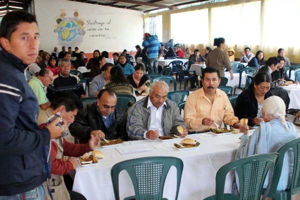 Padres de familia, maestros y estudiantes degustan un tamal, después de una alborada.