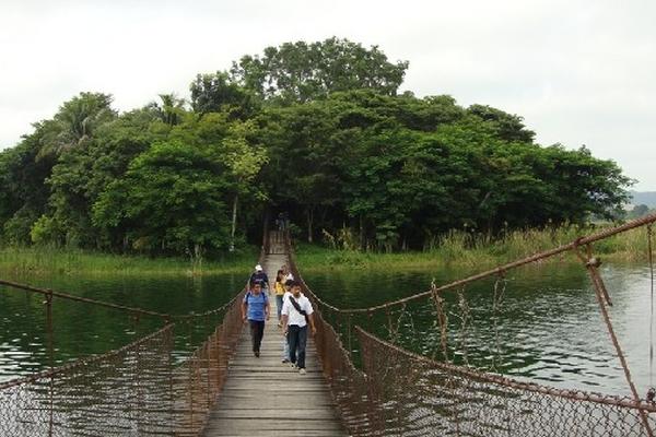 turistas y estudiantes llegan a través de un  puente colgante   a Petencito, un parque zoológico que la municipalidad de Flores, Petén,  cedió a  la Universidad de San Carlos de Guatemala.