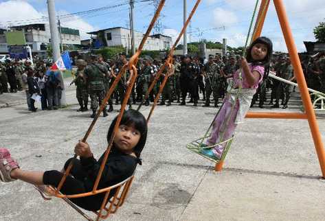 dos niñas se columpian mientras la fuerza de Tarea Maya queda instalada para reducir los índices de  violencia en siete colonias de  la zona 18.