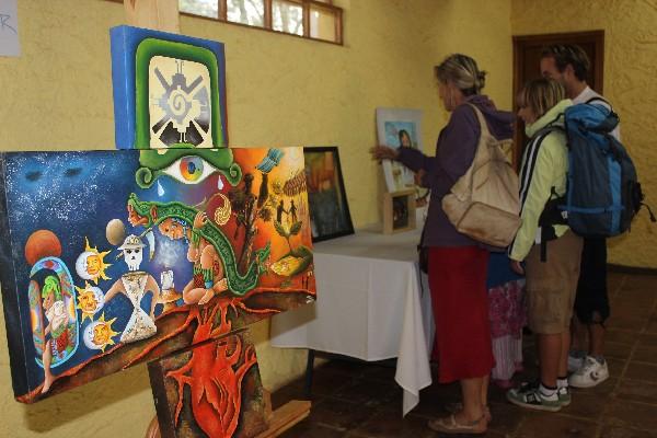 turistas observan algunas de las pinturas que fueron expuestas en el festival de arte maya,  en Iximché, Chimaltenango.