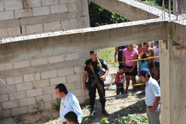 Curiosos observan el cadáver de Gerson Geniel Pérez, quien fue encontrado en San Andrés. (Foto Prensa Libre: Rigoberto Escobar)