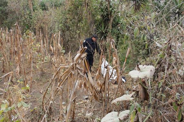 Agente de la PNC examina la escena del crimen donde perdió la vida un hombre en la cabecera de Chimaltenango. (Foto Prensa Libre: Víctor Chamalé)