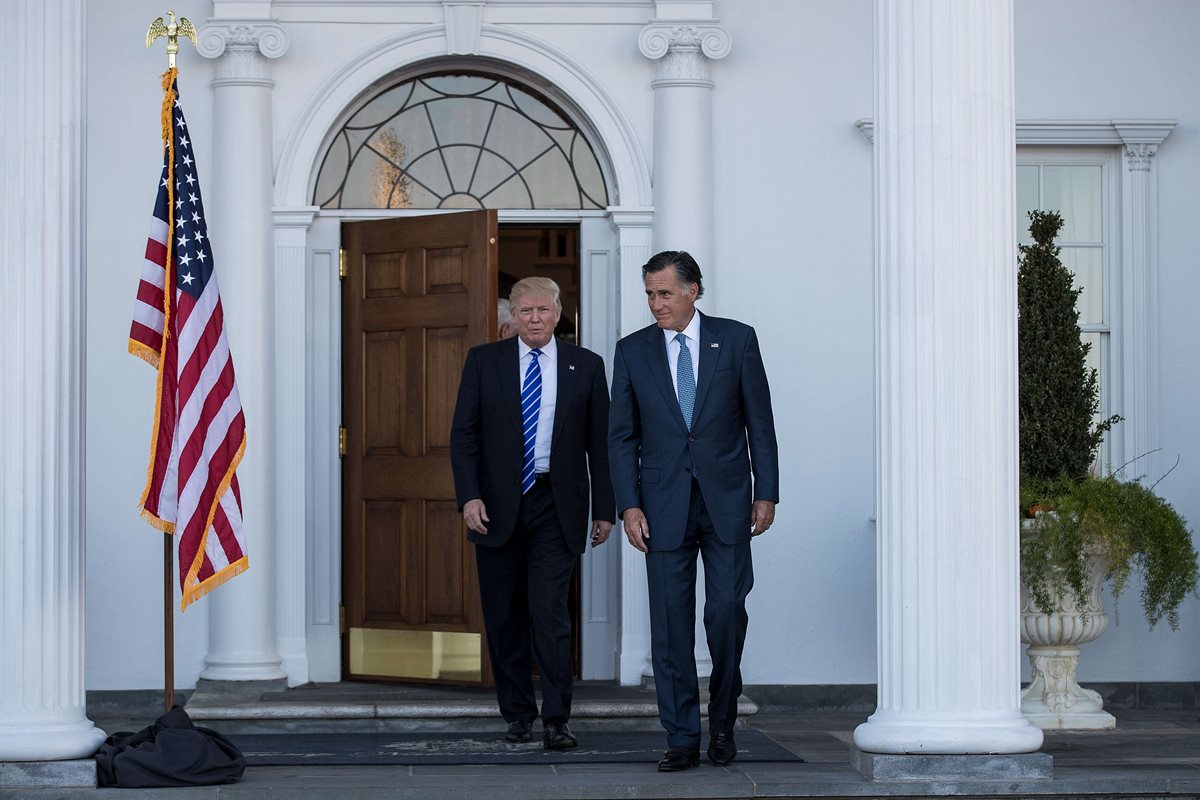 Donald Trump (izquierda), presidente electo de EE. UU., se reúne con el líder republicano Mitt Romney. (Foto Prensa Libre: AFP)