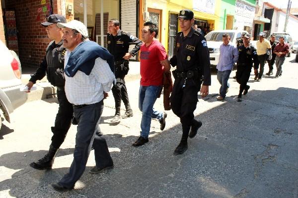 Agentes policiales custodian a presuntos responsables de destrozos en Chichicastenango.