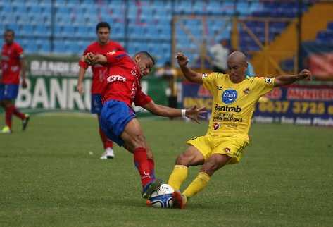 Duelo parejo.  Evandro Ferreira —izquierda— disputa fuertemente el balón con el defensa de Marquense Leonel Noriega, quien fue fundamental para impedir que los rojos ganaran. (Foto Prensa Libre: Eduardo González)