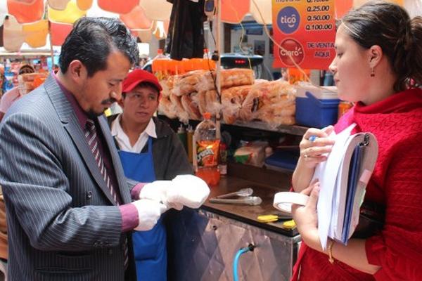 Personal de Salud Pública, acopañado de trabajadores de la municipalidad, supervisan ventas. (Foto Prensa Libre: Édgar Leonel Domínguez)<br _mce_bogus="1"/>