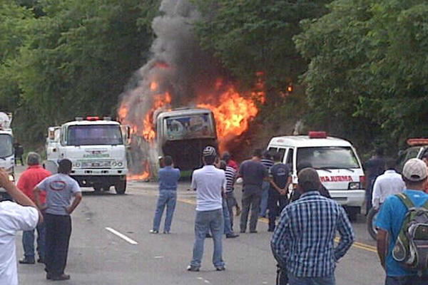 Curiosos observan las llamas que consumen un autobús pulman en el kilómetro 77 de la ruta al Atlántico, en Guastatoya. (Foto Prensa Libre: Eduardo Sam) <br _mce_bogus="1"/>