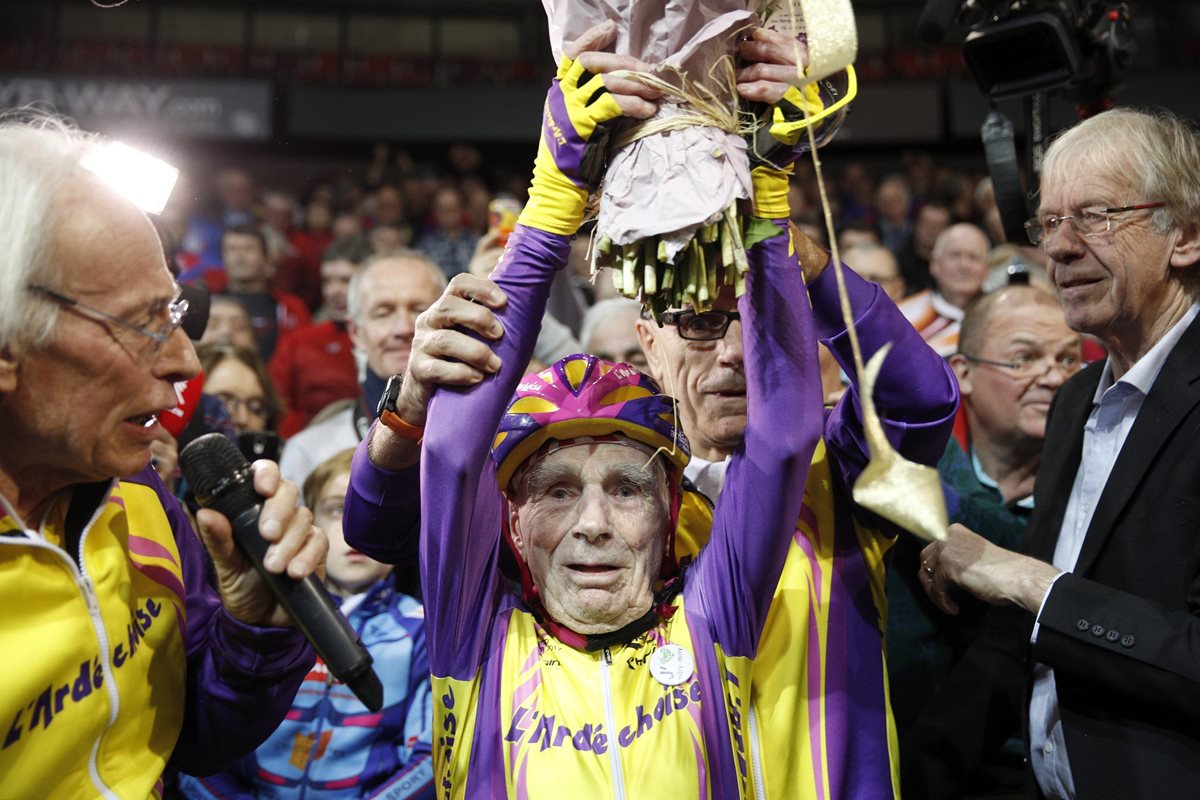 El aficionado francés de 105 años, Robert Marchand, sostiene un ramo de flores tras batir su propio récord de la hora en el velódromo de Saint-Quentin (Foto Prensa Libre: EFE)