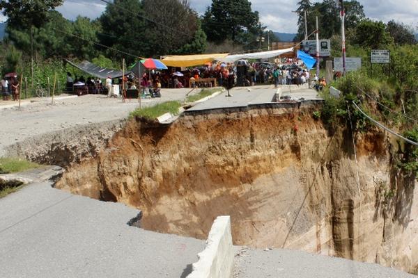 Un grupo de vecinos realiza actividades religiosas y ceremonias mayas a un costado del hundimiento en el kilómetro 147.5 de la ruta a Chichicastenango. (Foto Prensa Libre: Óscar Figueroa)<br _mce_bogus="1"/>