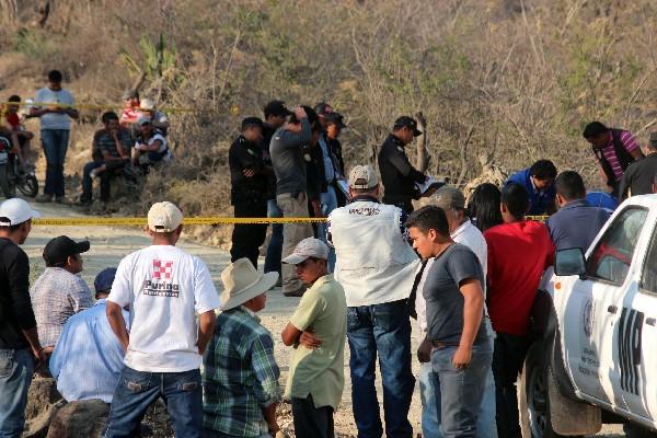 Autoridades y vecinos observan cadáver del agricultor Amílcar Méndez.