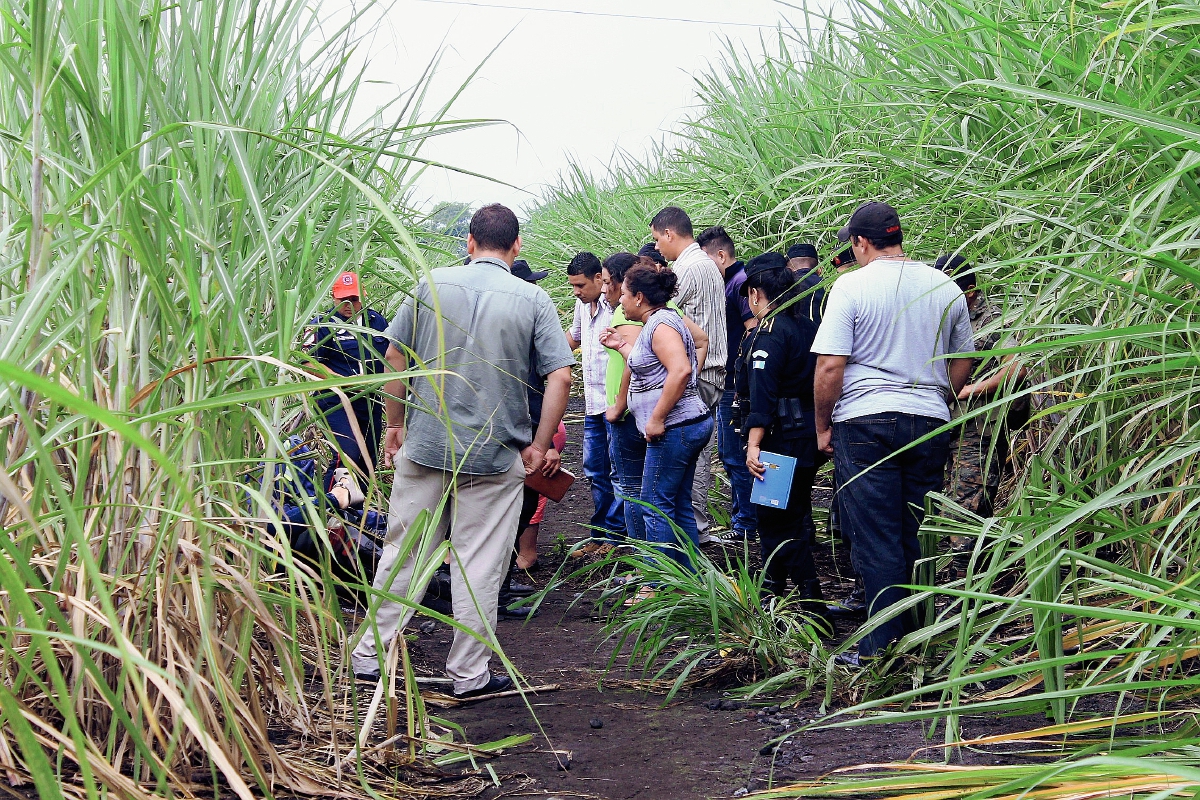 Vecinos y autoridades observan cadáveres de un hombre y una mujer, en Escuintla. (Foto Prensa Libre: Enrique Paredes)