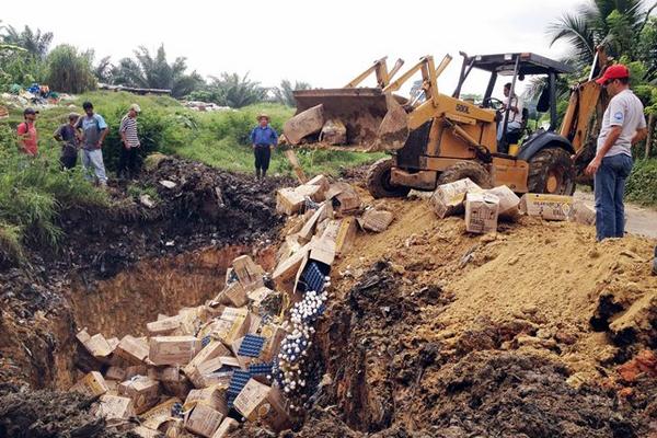 Una máquina entierra en Puerto Barrios, Izabal el lote de huevos decomisado en Livingston.   (Foto Prensa Libre: Edwin Perdomo)