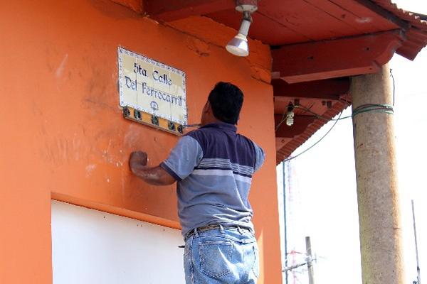 integrante del grupo  gestor  coloca nomenclatura en una calle de Retalhuleu.