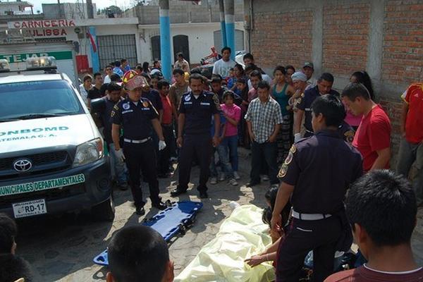 Curiosos observan el cadáver de Carlos Roberto Sitalán, quien murió baleado en El Tejar. (Foto Prensa Libre: Víctor Chamalé)