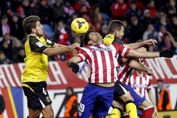 Diego Costa, del Atlético de Madrid, lucha por el balón con el jugador de Sevilla, Daniel Carrico. (Foto Prensa Libre: EFE)