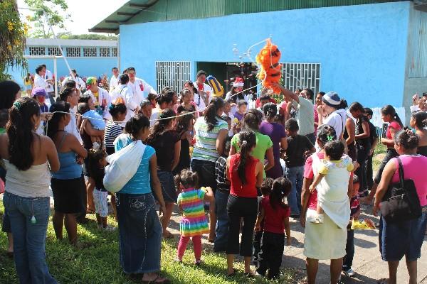 Niños y sus madres quiebran una piñata en un área del Hospital Regional de Coatepeque, Quetzaltenango.