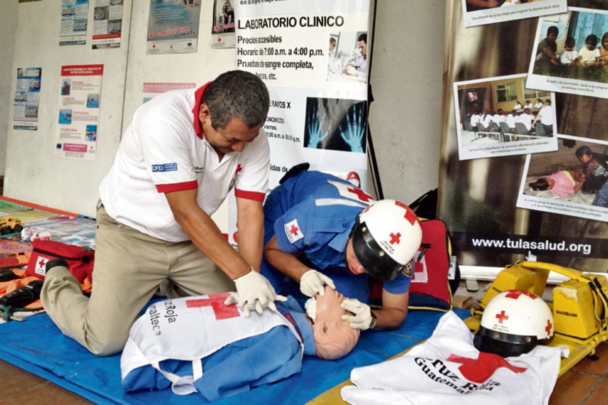 Socorristas de la Cruz Roja realizan un simulacro de primeros auxilios durante feria informativa sobre gestión de riesgo, en Cobán.