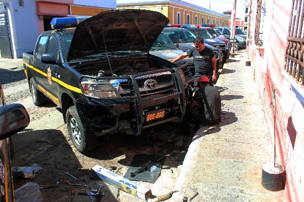 Mecánicos reparan un   autopatrulla  de la PNC   de Xelajú,  frente  a la Comisaría  41.