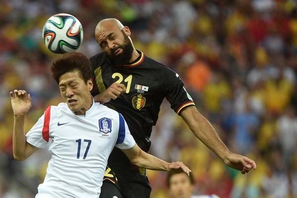 El coreano Lee Chung-Yong disputa el balón con Anthony Vanden de Bélgica. (Foto Prensa Libre: AFP)