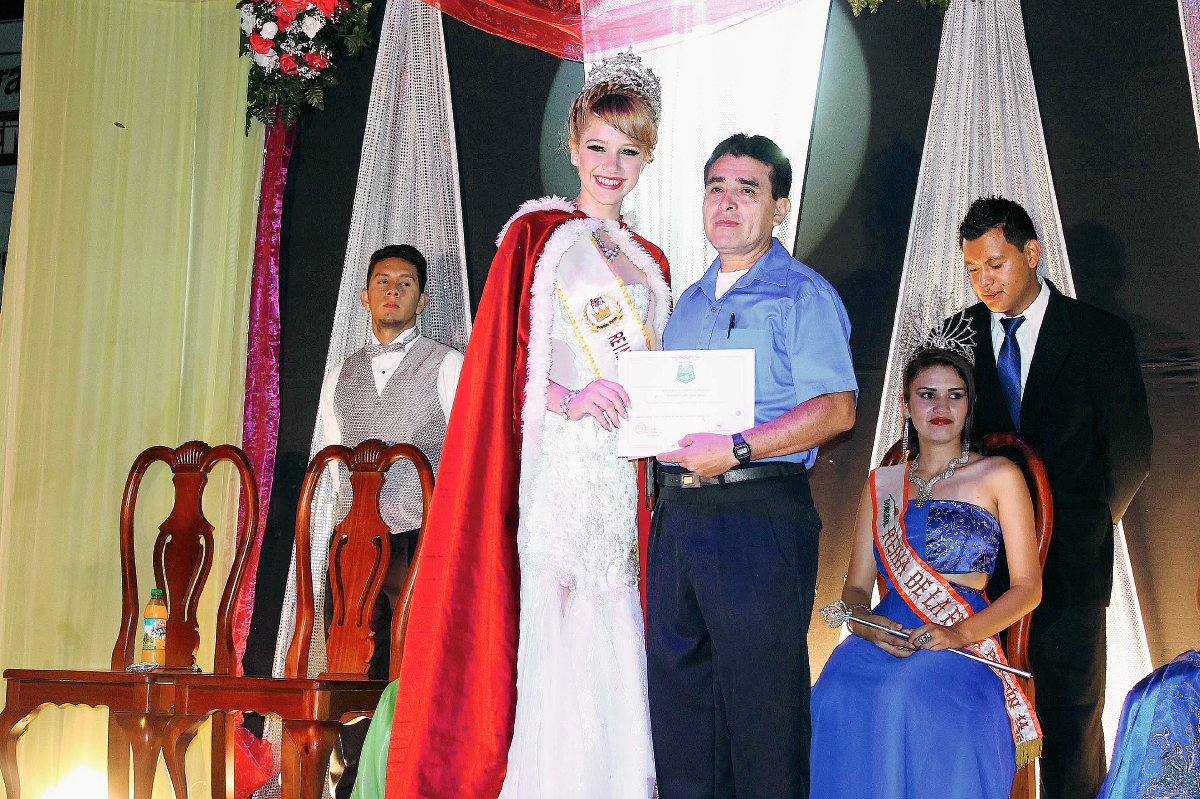 Katheryn Orrego, reina de la feria de Poptún, entrega reconocimiento al escritor Salvador Castellanos.  (Foto Prensa Libre: Walfredo Obando)