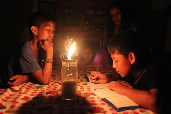 Niños estudian al amparo de una vela en una casa en Flores, Petén. (Foto Prensa Libre: Rigoberto Escobar)<br _mce_bogus="1"/>