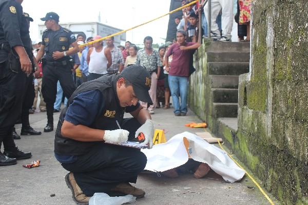 Agente del Ministerio Público recaba evidencias de la víctima, en la terminal de Mazatenango.