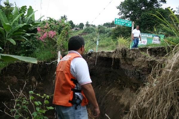 Un delegado  de la Conred observa el socavamiento que podría hacer caer parte de la cinta asfáltica, en el kilómetro 63.5 de la ruta a El Salvador.