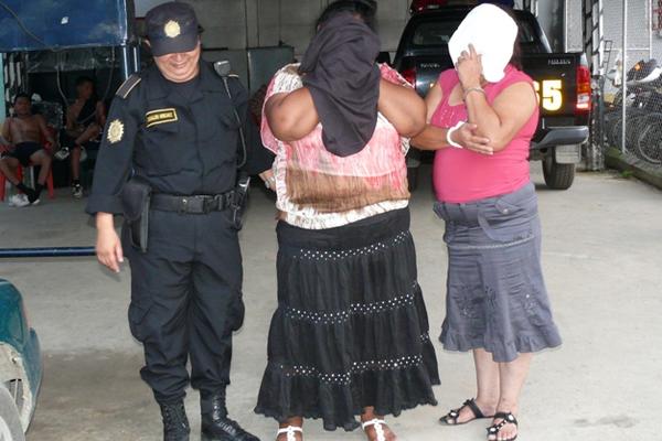 Una agente de la PNC traslada a las dos mujres que fueron detenidas en la cárcel de Puerto Barrios. (Foto Prensa Libre: Edwin Perdomo)<br _mce_bogus="1"/>